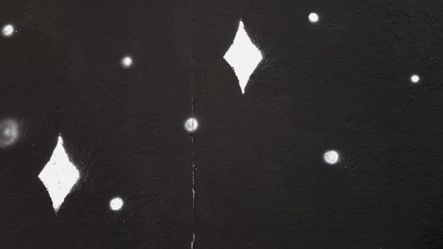 High-quality creative background for advertising, banners, holiday cards. Black concrete painted wall with white spots in the form of highlights or stars.