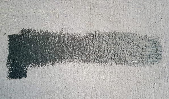 Gray concrete wall. Large coarse strokes of paint on the surface of the house. Close-up. Classic background. Copy space. Place for text