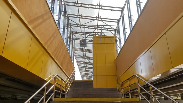 Ukraine, Kiev - September 24, 2019: light rail station. Design of a bus stop and a pedestrian underpass with steps and railings made of yellow panels and a glass roof