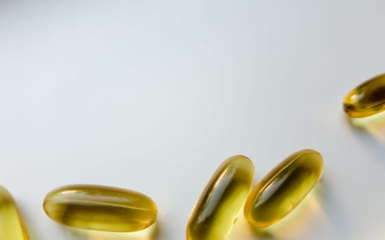 Fish oil capsules isolated on white background with copy space, top view. Omega-3 high resolution product. Food supplement. Healthy lifestyle. Fatty acids in tablets. Metabolism in the body