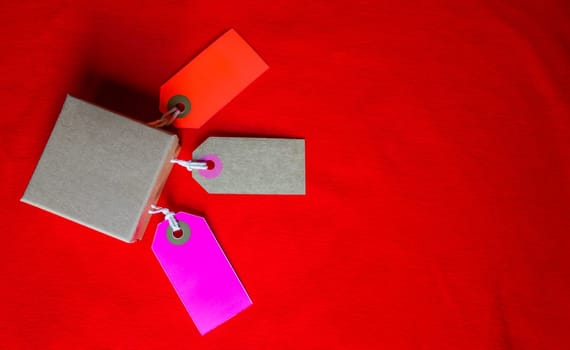 Cardboard boxes with a tag. Brown packing box with blank label and copy space on red backdrop.