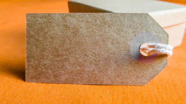 Cardboard boxes with a tag. Brown packing box with blank label and copy space on red backdrop.