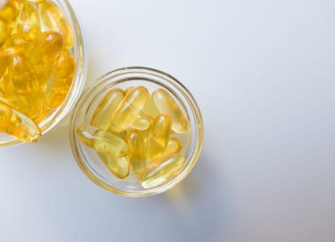 Fish oil capsules on a glass plate. A lot of vitamin omega 3 on a white background. Close-up, top view, high resolution product. Metabolism in the body. The body of calcium. A quick way to lose weight.