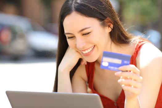 Asian woman buying online with credit card and laptop