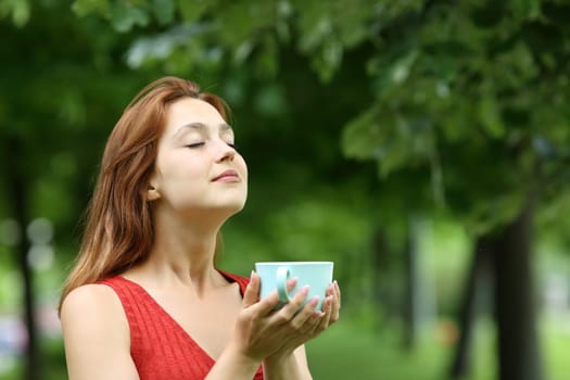 Woman holding coffee cup breathing fresh air