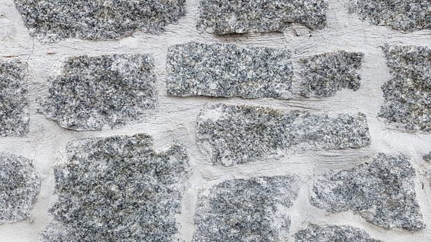 Gray stone wall background. The texture of the stone. Old castle wall background. Stone wall as a background or texture. Part of the wall, for background or texture