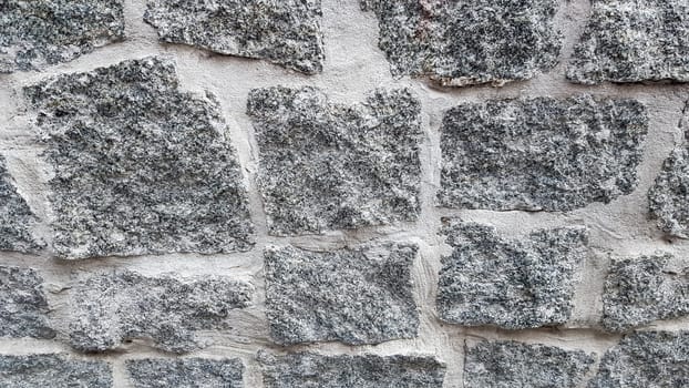 Gray stone wall background. The texture of the stone. Old castle wall background. Stone wall as a background or texture. Part of the wall, for background or texture