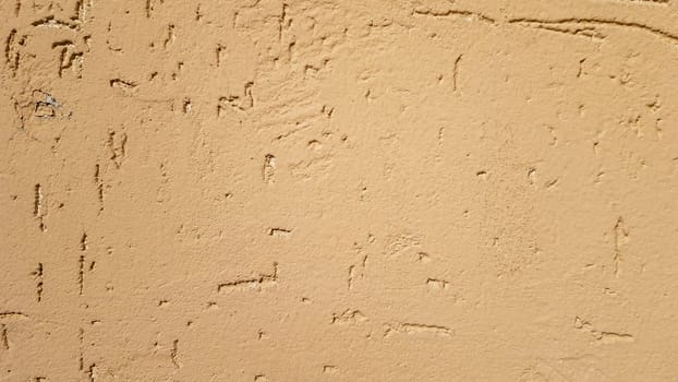 Old gold plaster wall texture yellow background. Textured textured wall plaster. Embossed wall decoration. Stucco walls. Embossed wall decoration. Decorative plaster is painted yellow
