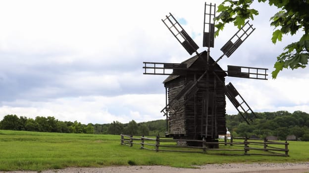 Ukraine, Kiev - June 11, 2020. Old Ukrainian wooden windmills of the XIX century. Summer outdoor landscape. Open-air museum of folk architecture and life, Pirogovo, Ukraine. Tourism and travel