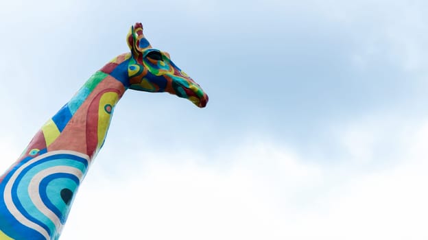 Ukraine, Kiev - June 2, 2020. A beautiful and bright statue of a giraffe is painted in different colors in front of the main entrance to the Kiev Zoo. Reconstruction and opening of the zoo