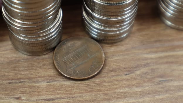 Coins are stacked on a wooden work table. Stock photo of many cents.