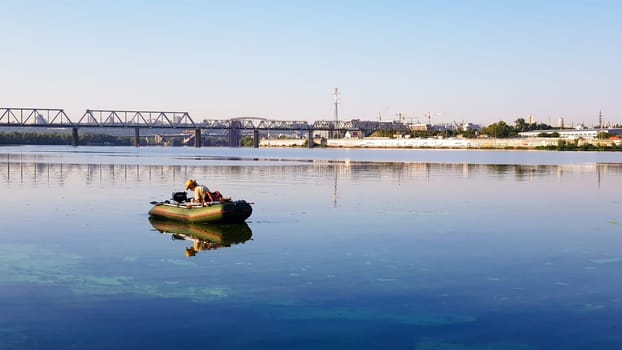 Ukraine, Kiev - August 20, 2019: fishing. Fisherman on an inflatable boat with fishing tackle on a river in the city limits on a sunny summer morning