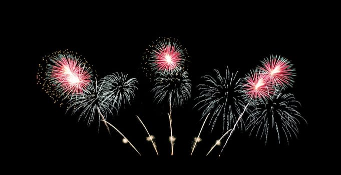 Red and green fireworks sparkling on night sky celebration