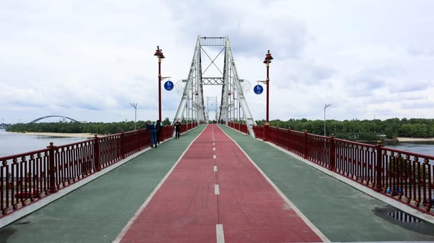 Ukraine, Kiev - June 2, 2020: Park pedestrian bridge over the Dnieper River, which connects the central part of Kiev with the park area and the beaches of Trukhanovy Island. Without people