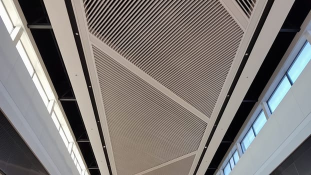 Ceiling finish. Lattice white suspended ceiling, interior decoration of commercial buildings. Ceiling interiors in a shopping mall with lighting