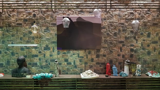 Ukraine, Kiev - June 10, 2020. Modern living room of a large house with a kitchen, fireplace, green sofa and red soft chairs, steps to the second floor, ice lights and lamps, decoration elements.