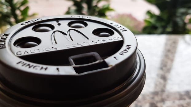 Close-up of McDonald's fast food restaurant logo on a black paper cup lid with hot McCafe coffee. Breakfast, coffee time. Ukraine, Kiev - September 30, 2020