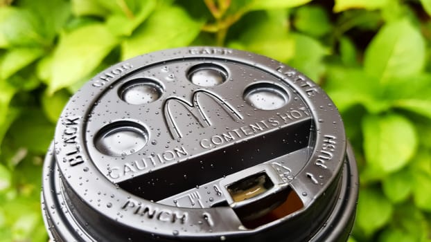 Close-up of McDonald's fast food restaurant logo on a black paper cup lid with hot McCafe coffee. Breakfast, coffee time. Ukraine, Kiev - September 30, 2020