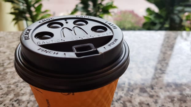 Close-up of McDonald's fast food restaurant logo on a black paper cup lid with hot McCafe coffee. Breakfast, coffee time. Ukraine, Kiev - September 30, 2020