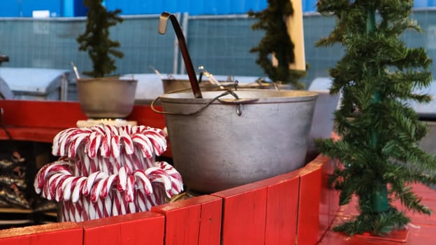 Mulled wine cooked on a fire outside. Vitamins in a winter drink. Street eatery at the Christmas market in winter. Hot mulled wine. Dense steam over cauldrons of hot wine