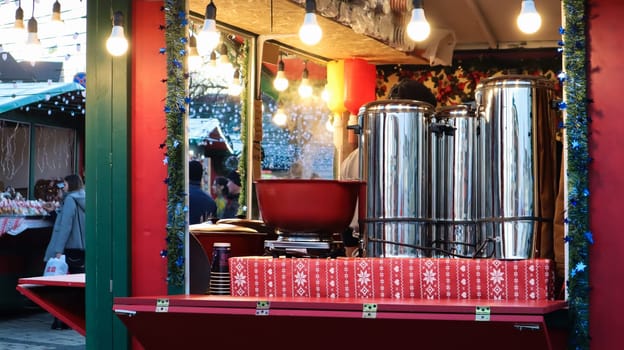 Ukraine, Kiev - January 7, 2020. Winter hot drink lintwein on a campfire on the street. Street diner at the Christmas market in winter. Hot mulled wine. Dense steam over boilers of hot wine.
