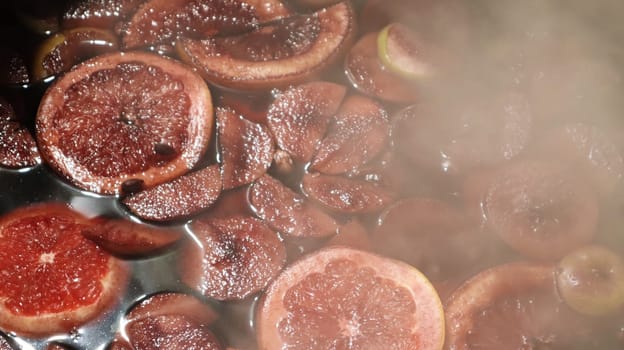 Mulled wine cooked on a fire outside. Close up. Vitamins in a winter drink. Street eatery. Hot mulled wine. Dense steam over cauldrons of hot wine