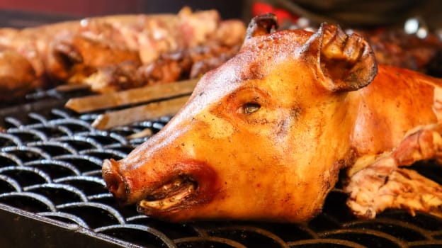 The head of a whole fried pig. Grilled pork. fried pork head. Babi Guling is a crispy fried pig, a favorite Indonesian street food in Bali. Zoological image of a pig showing its head. country animal.