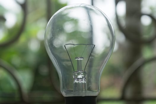 Closeup filament of Older style Incandescent Clear Light bulb isolated from background.
