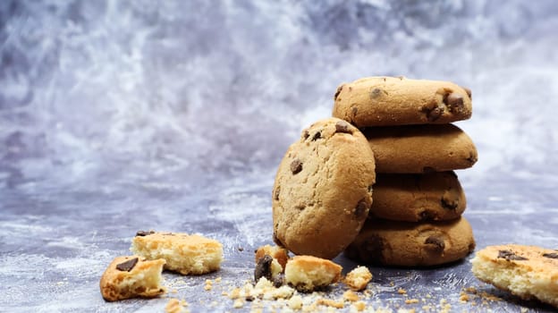 American chocolate chip cookies stacked on top of each other on a beautiful gray marble background. Traditional rounded crunchy dough with chocolate chips. Bakery. Delicious dessert, pastries