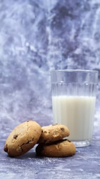 American gluten free chocolate chip cookies with glass glass of vegetable milk on gray background. Chocolate chip cookies. Sweet pastries, dessert. Culinary background. Vertical photography
