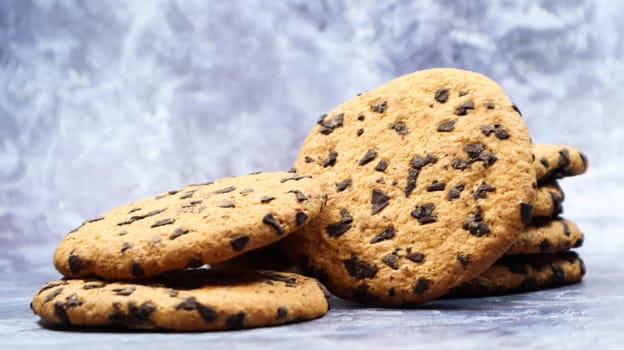 Soft, freshly baked chocolate chip cookies on a gray marble kitchen countertop. American traditional sweet pastry pastry, delicious homemade dessert. Culinary background