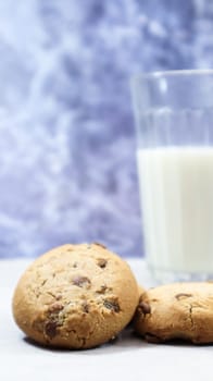 American gluten free chocolate chip cookies with glass glass of vegetable milk on gray background. Chocolate chip cookies. Sweet pastries, dessert. Culinary background. Vertical photography