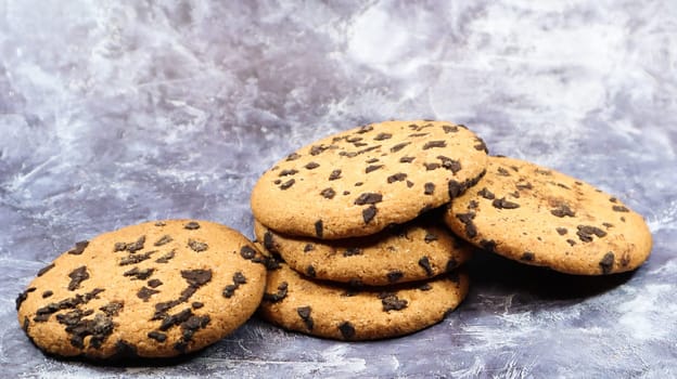 Soft, freshly baked chocolate chip cookies on a gray marble kitchen countertop. American traditional sweet pastry pastry, delicious homemade dessert. Culinary background