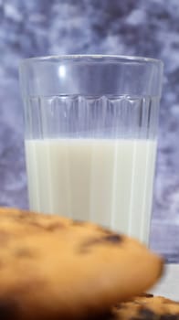 American gluten free chocolate chip cookies with glass glass of vegetable milk on gray background. Chocolate chip cookies. Sweet pastries, dessert. Culinary background. Vertical photography