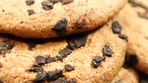 Soft, freshly baked chocolate chip cookies on a gray marble kitchen countertop. American traditional sweet pastry pastry, delicious homemade dessert. Culinary background. Close-up.