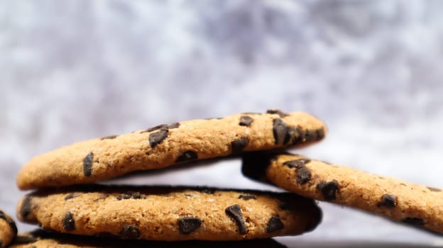 American chocolate chip cookies stacked on top of each other on a beautiful gray marble background. Traditional rounded crunchy dough with chocolate chips. Bakery. Delicious dessert, pastries