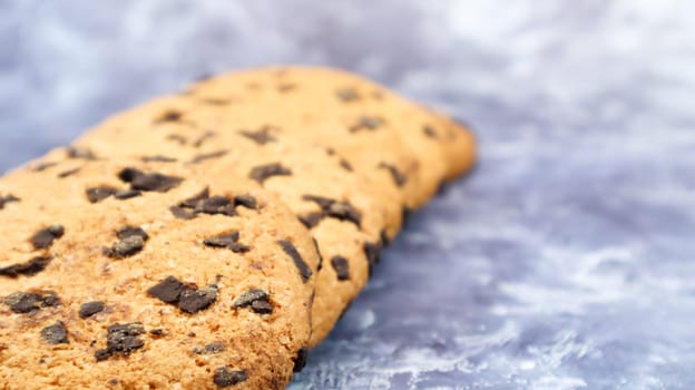 Soft, freshly baked chocolate chip cookies on a gray marble kitchen countertop. American traditional sweet pastry pastry, delicious homemade dessert. Culinary background. Copy space.
