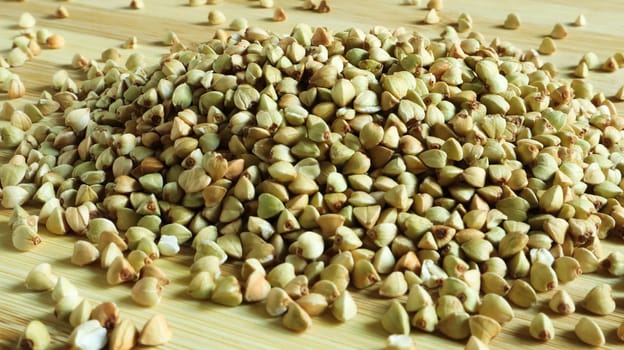 Green buckwheat seeds on a wooden background. Great food. healthy groats. Organic raw non-fried vegetarian food. The concept of a healthy, balanced and dietary diet. Copy space