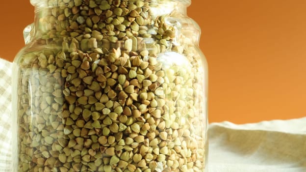 Green sprouts of raw organic buckwheat in a glass jar for cereals. Vegan food concept. Organic food. The concept of diet, weight loss, healthy and proper nutrition. Copy space for text