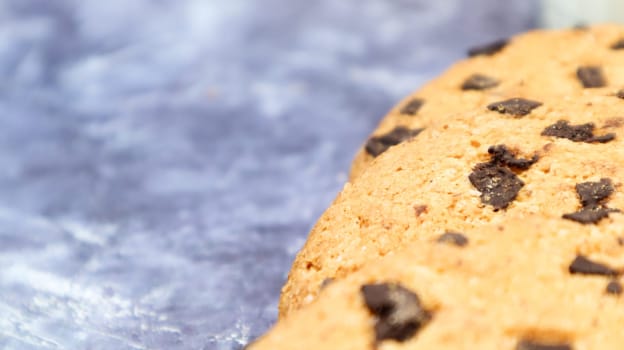 Soft, freshly baked chocolate chip cookies on a gray marble kitchen countertop. American traditional sweet pastry pastry, delicious homemade dessert. Culinary background. Copy space.