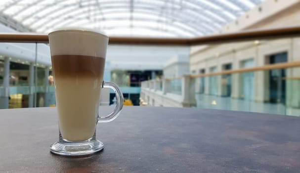 Classic coffee latte macchiato in a glass cup on the table. Glass cup with hot drink