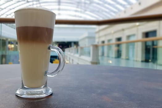 Classic coffee latte macchiato in a glass cup on the table. Glass cup with hot drink