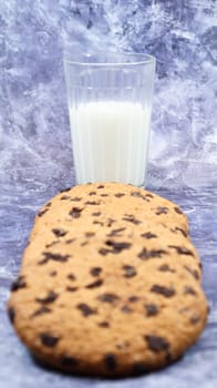 American gluten free chocolate chip cookies with glass glass of vegetable milk on gray background. Chocolate chip cookies. Sweet pastries, dessert. Culinary background. Vertical photography