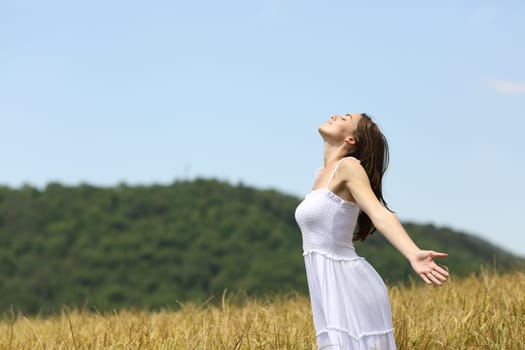 Profile of a woman breathing fresh air in a wheat field on summer