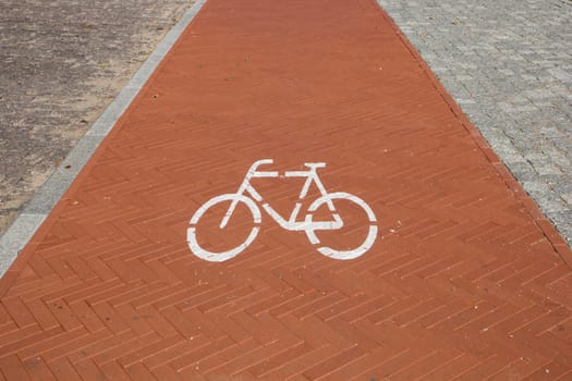 red paved bike path with a bike sign on it