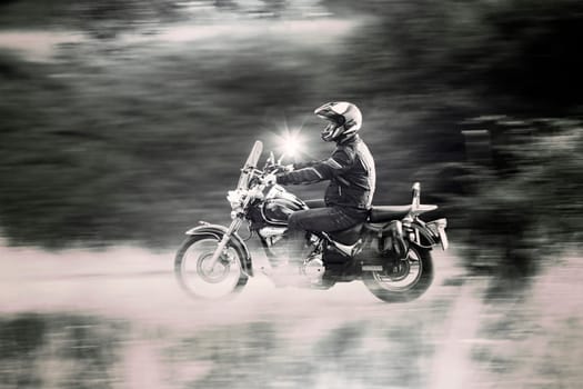 Motorcycle driver driving in beautiful sunset.