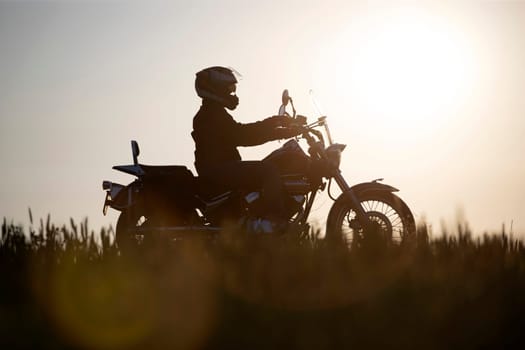 Motorcycle driver riding on countryside hills. Travel and sport, speed and freedom concept