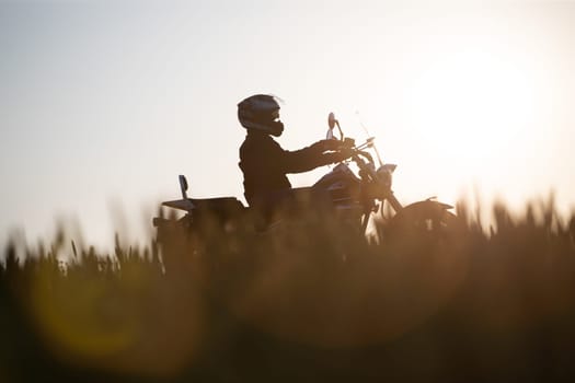 Motorcycle driver riding on countryside hills. Travel and sport, speed and freedom concept