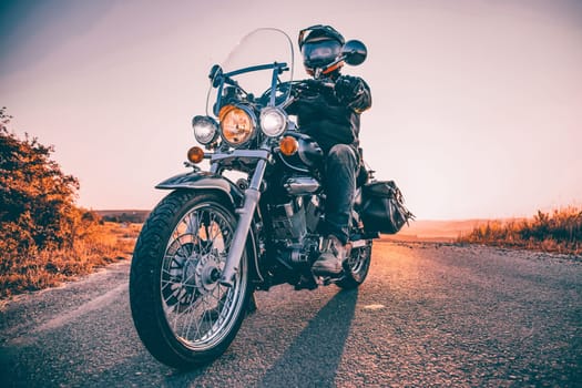 Motorcycle driver riding on countryside. Travel and sport, speed and freedom concept