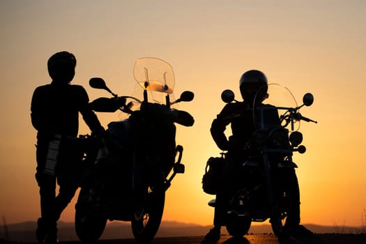 Motorcycle couple in sunset with classic motorcycle